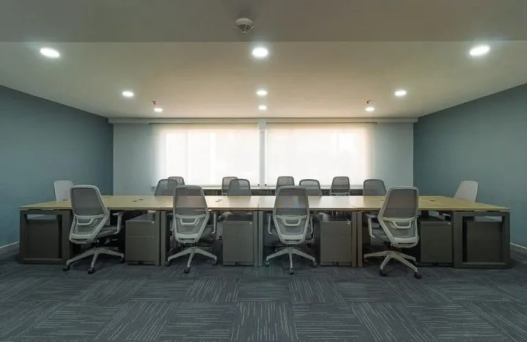 Sala de capacitación en la Torre Tequendama con downlights empotrados sobre una mesa larga de trabajo