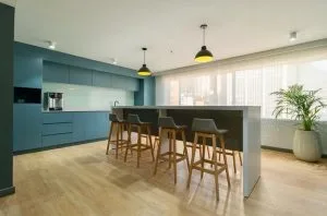 Cafetería de las oficinas del piso 4 de la Torre Tequendama con dos lámparas colgantes sobre la barra y downlights