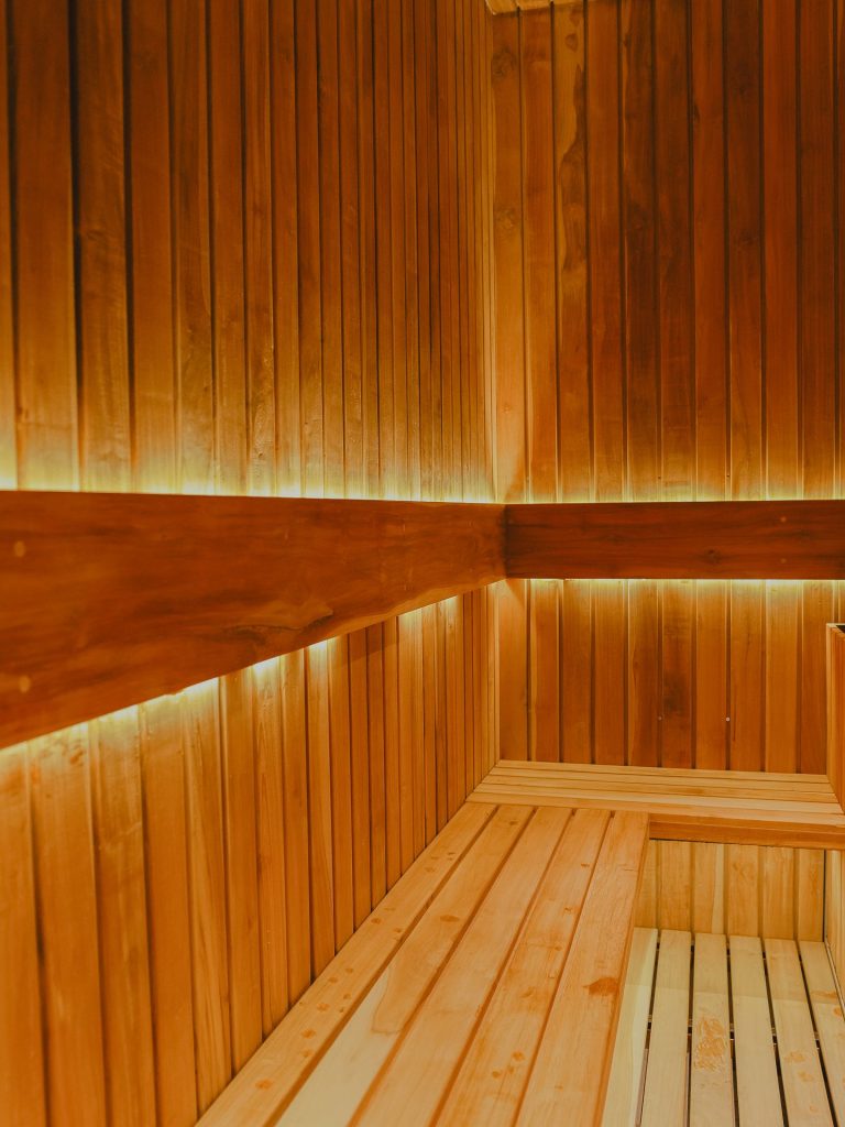 Muro con luminarias empotradas de luz cálida en el pasillo de la piscina, Edificio Tempo
