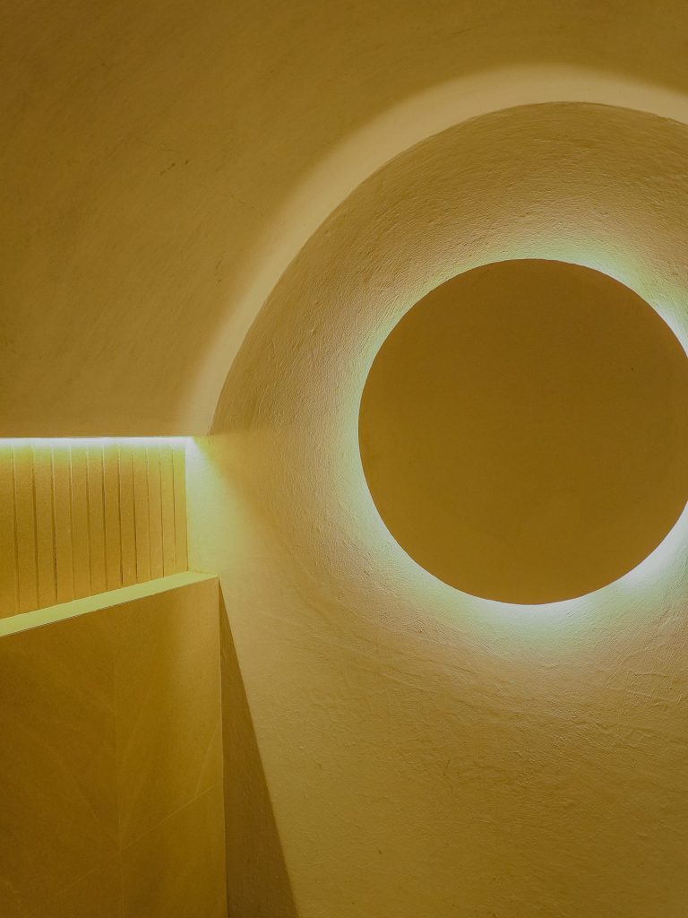 Nicho circular con luz LED perimetral en muro texturizado, Edificio Tempo
