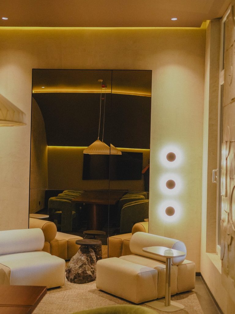 Lounge con espejo iluminado y luminarias circulares de pared, Edificio Tempo